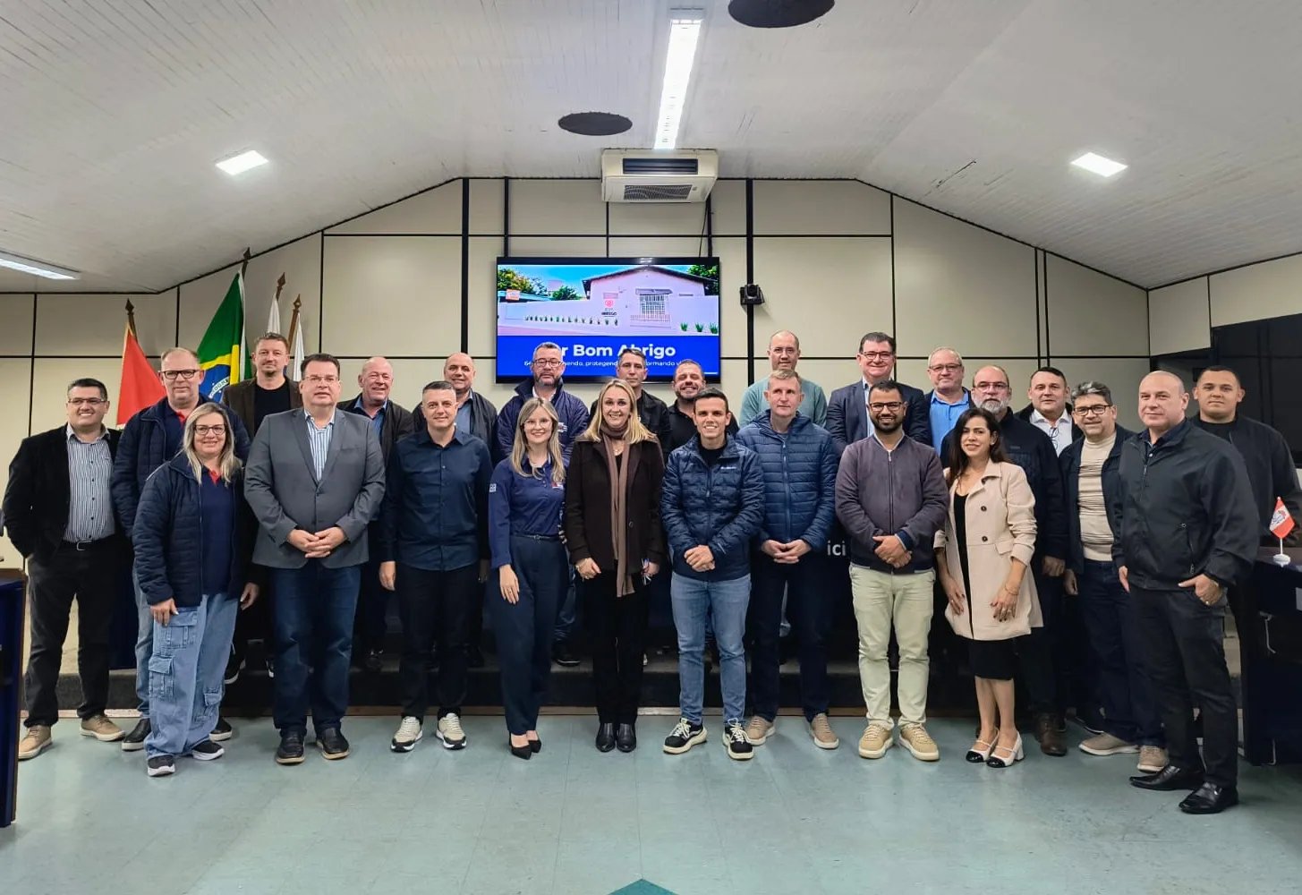 Plenário de câmara municipal com mesas e cadeiras