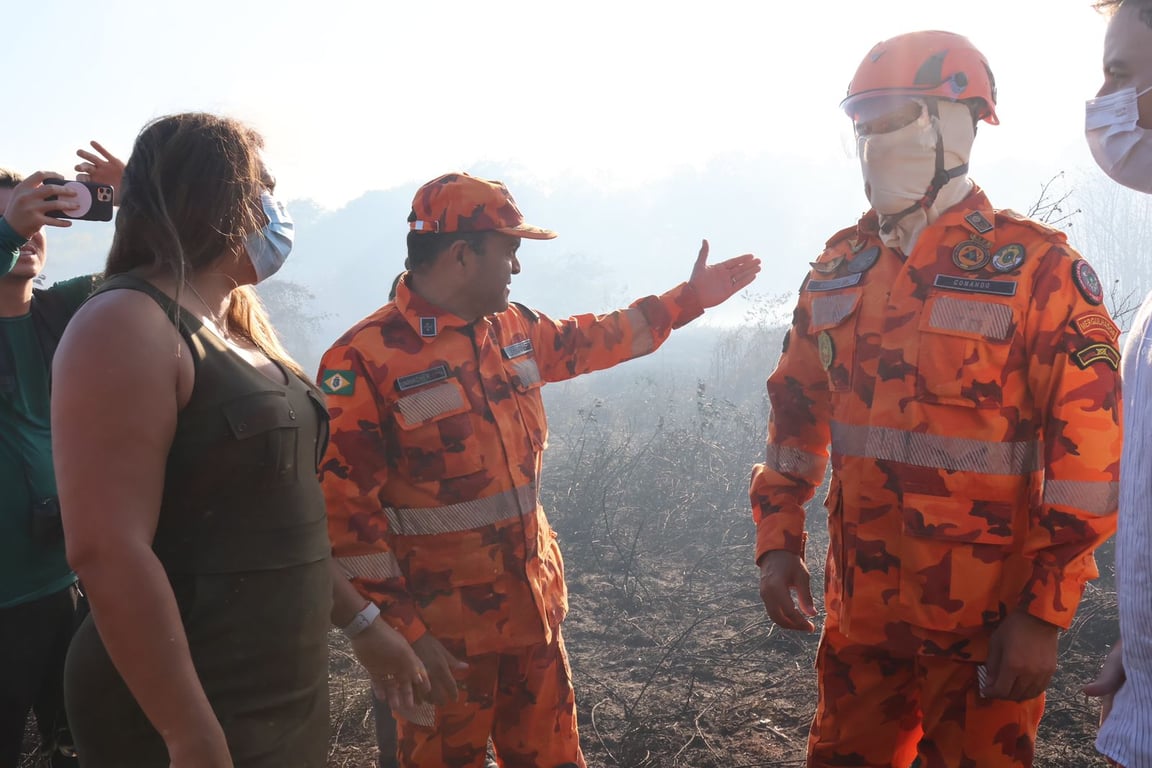 Brigadistas combatendo fogo de baixa intensidade no Cerrado, com fumaça ao fundo