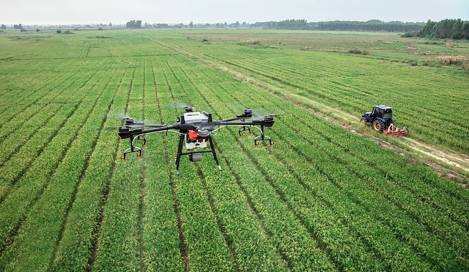 Tecnologia agrícola: drone e trator em operação em lavoura de soja