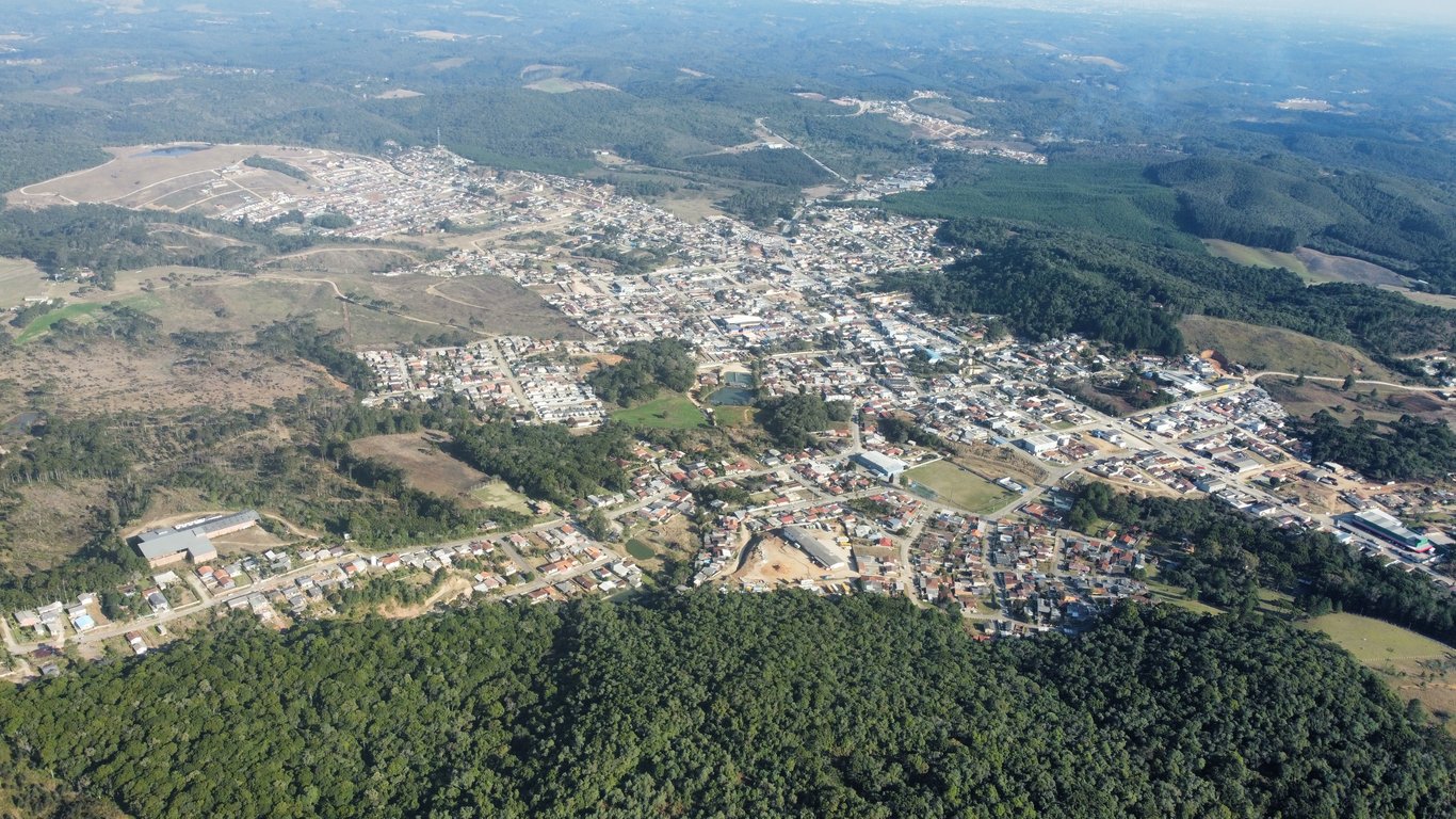 Vista aérea de Bocaiúva do Sul (PR), com áreas urbanas e vegetação ao redor, cercadas por serras.