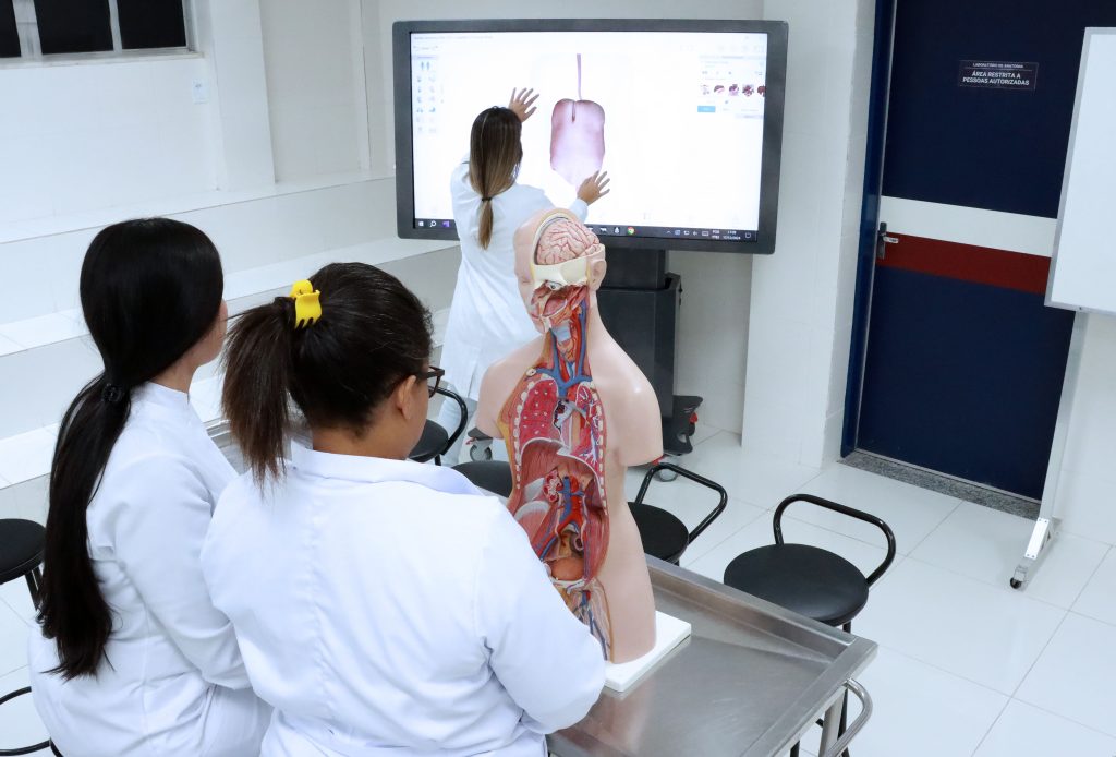 Laboratório acadêmico de saúde com professor e estudantes