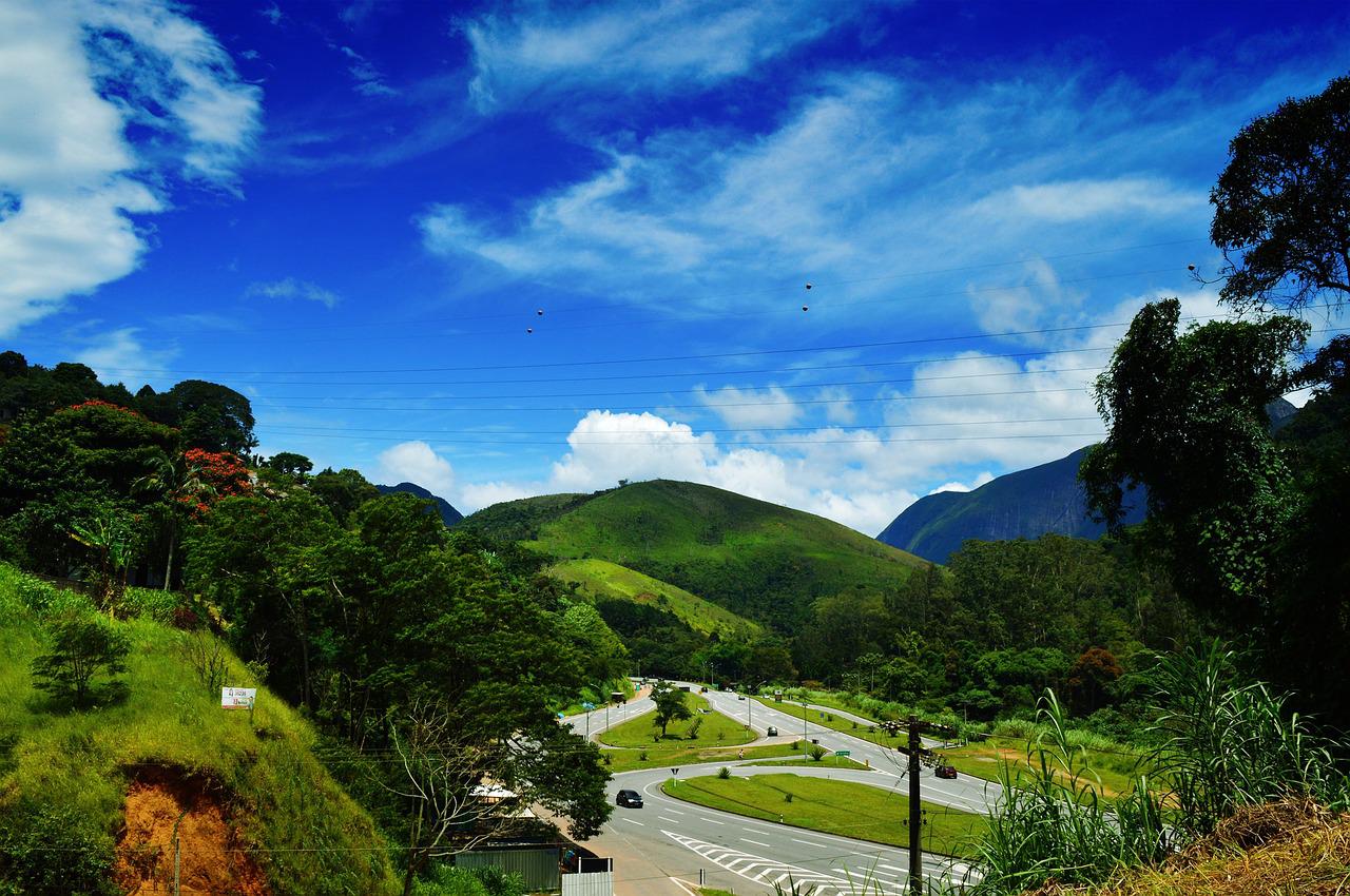 Paisagem serrana de Petrópolis, com morros cobertos por Mata Atlântica em dia claro
