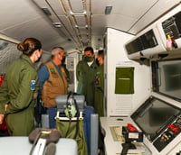 Tripulantes da Força Aérea Brasileira em operação no interior de uma aeronave.