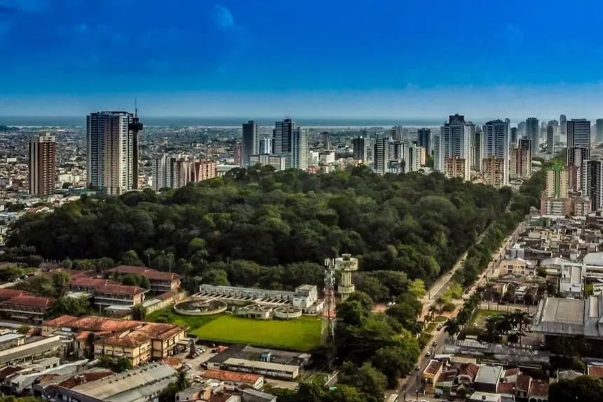 Vista aérea de Benevides, com áreas urbanas e vegetação em dia ensolarado.