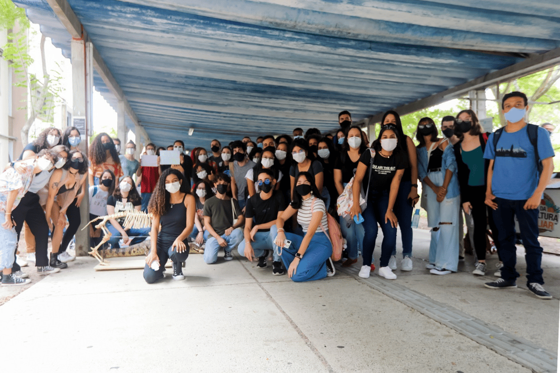 Corredor de campus com estudantes em circulação, imagem ilustrativa de vida universitária