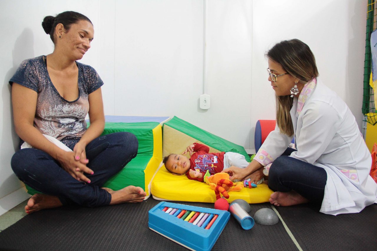 Profissional de saúde realizando avaliação de fala com criança em UBS
