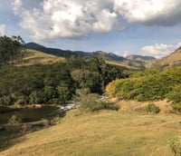 Vista aérea de Itajubá MG, com morros da Serra da Mantiqueira e área urbana ao entardecer