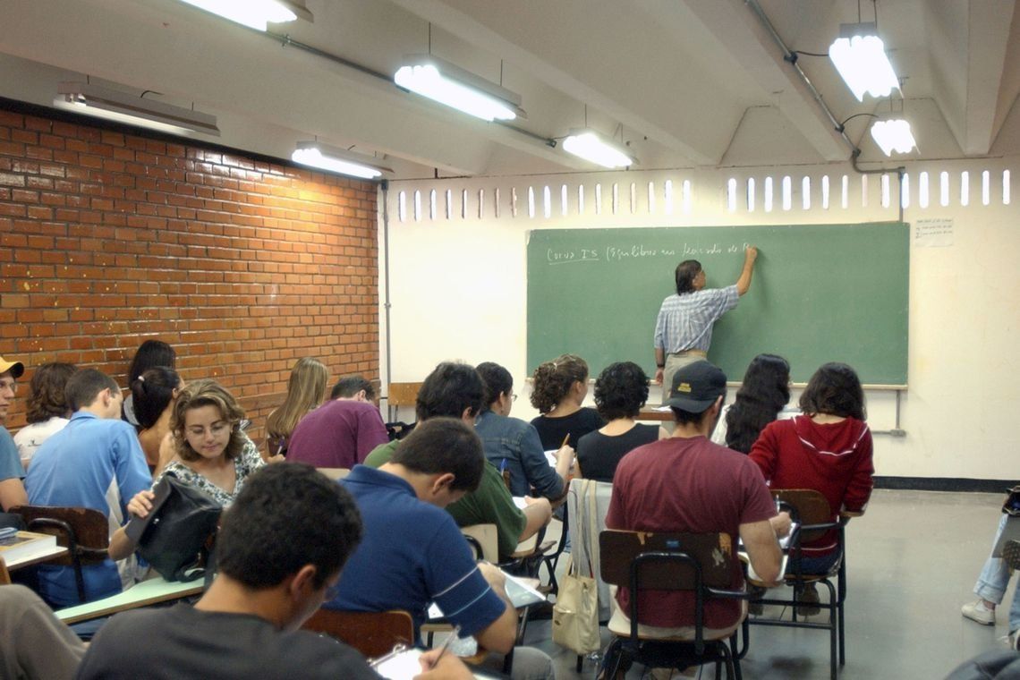 Sala de aula da rede pública, com professor e estudantes em atividade