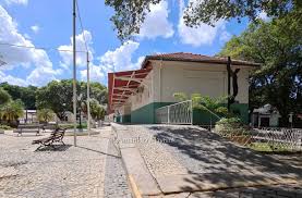 Centro urbano de cidade da Zona da Mata mineira, com praça e céu parcialmente nublado