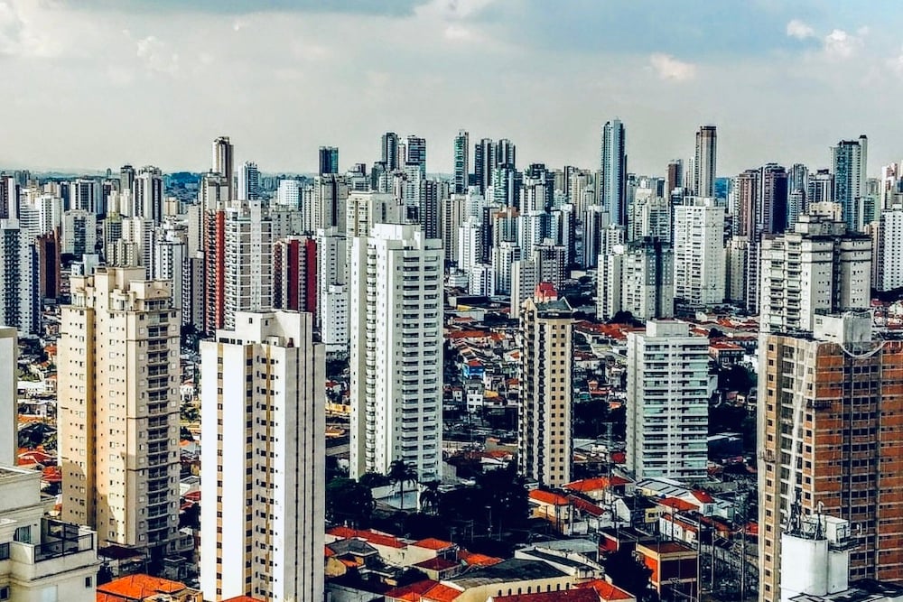 Vista aérea de bairro da Zona Sul de São Paulo, com áreas verdes e prédios residenciais ao entardecer.