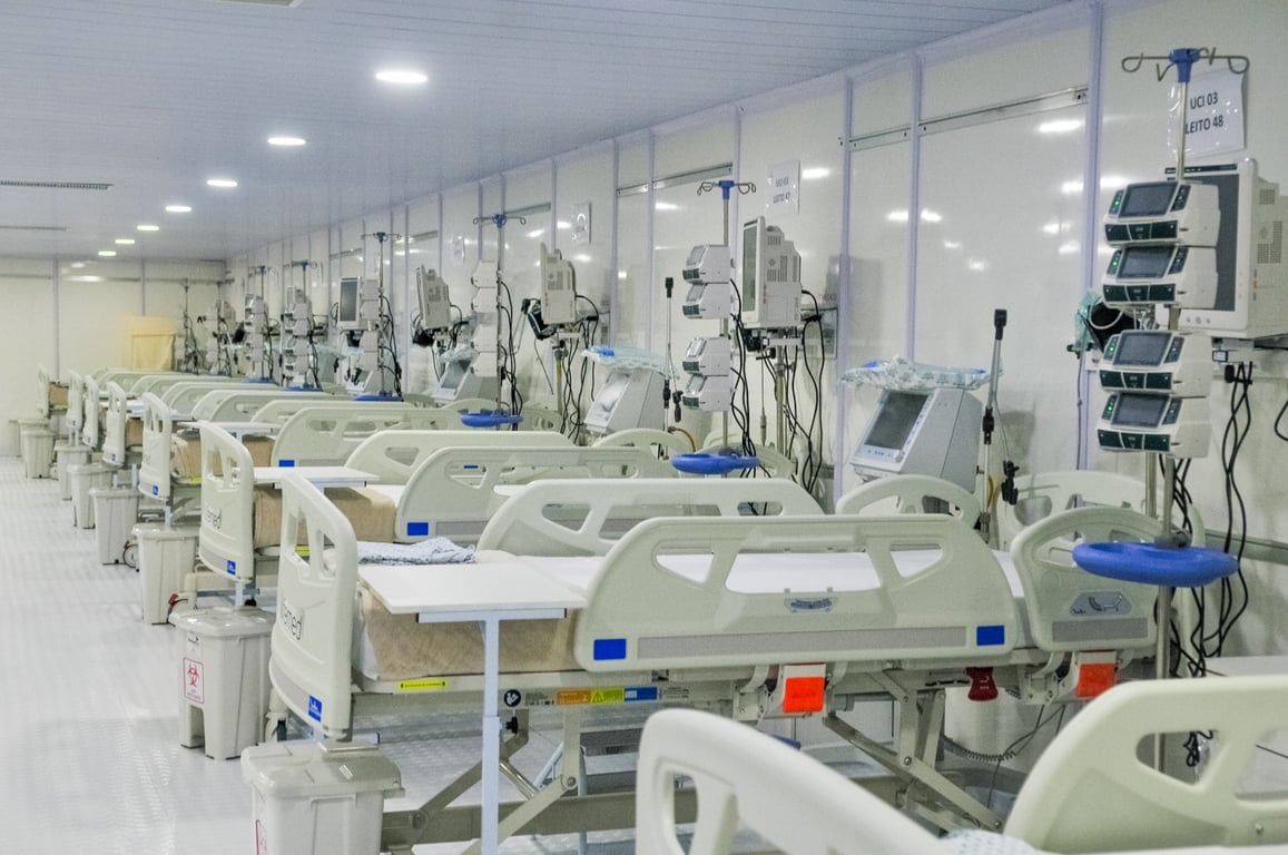 Corredor de hospital público moderno, com leitos e equipamentos médicos