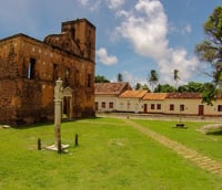 Vista urbana de São Simão SP com igreja e área verde ao fundo.