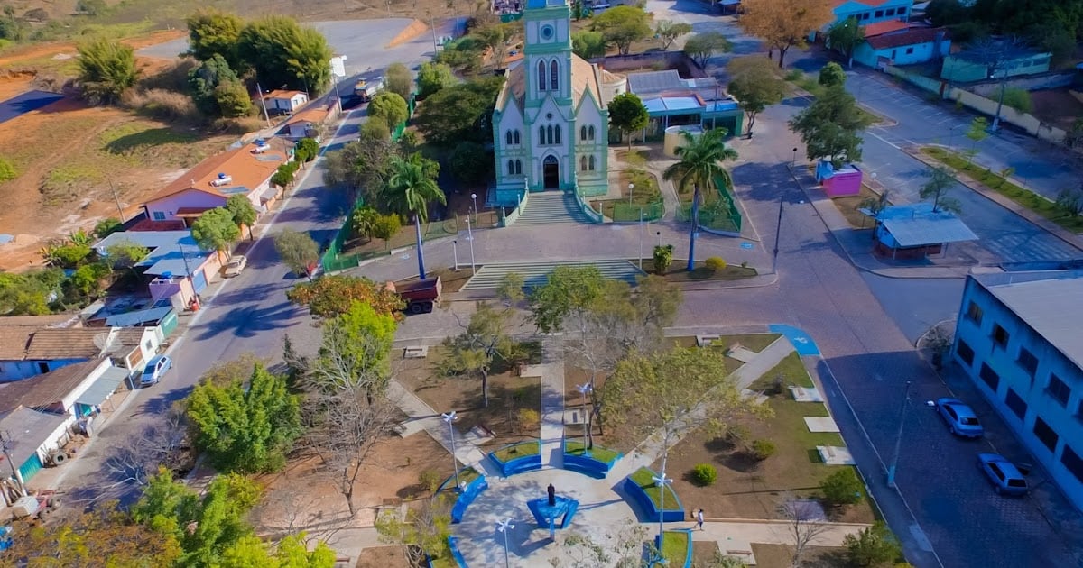 Praça central de Leandro Ferreira MG em dia ensolarado, com a igreja matriz ao fundo