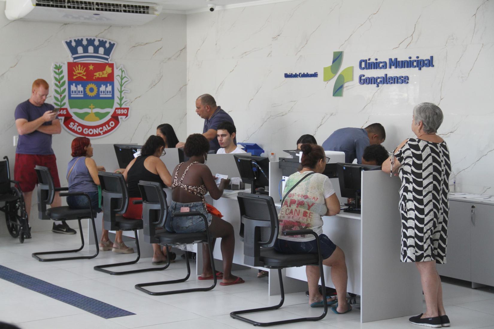 Atendimento em unidade de saúde brasileira com profissionais e usuários em estações de trabalho
