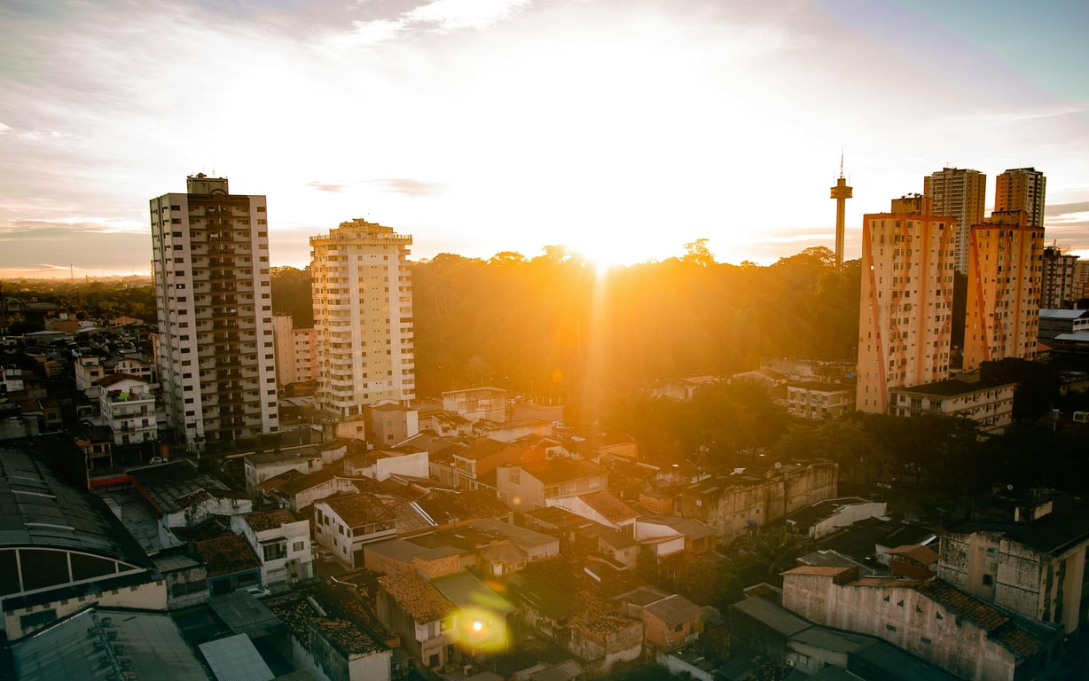 Skyline de Goiânia ao entardecer, com prédios e céu alaranjado