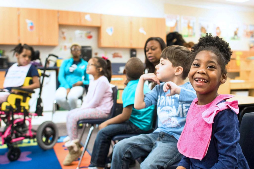 Sala de aula inclusiva com tecnologia assistiva e estudantes diversos