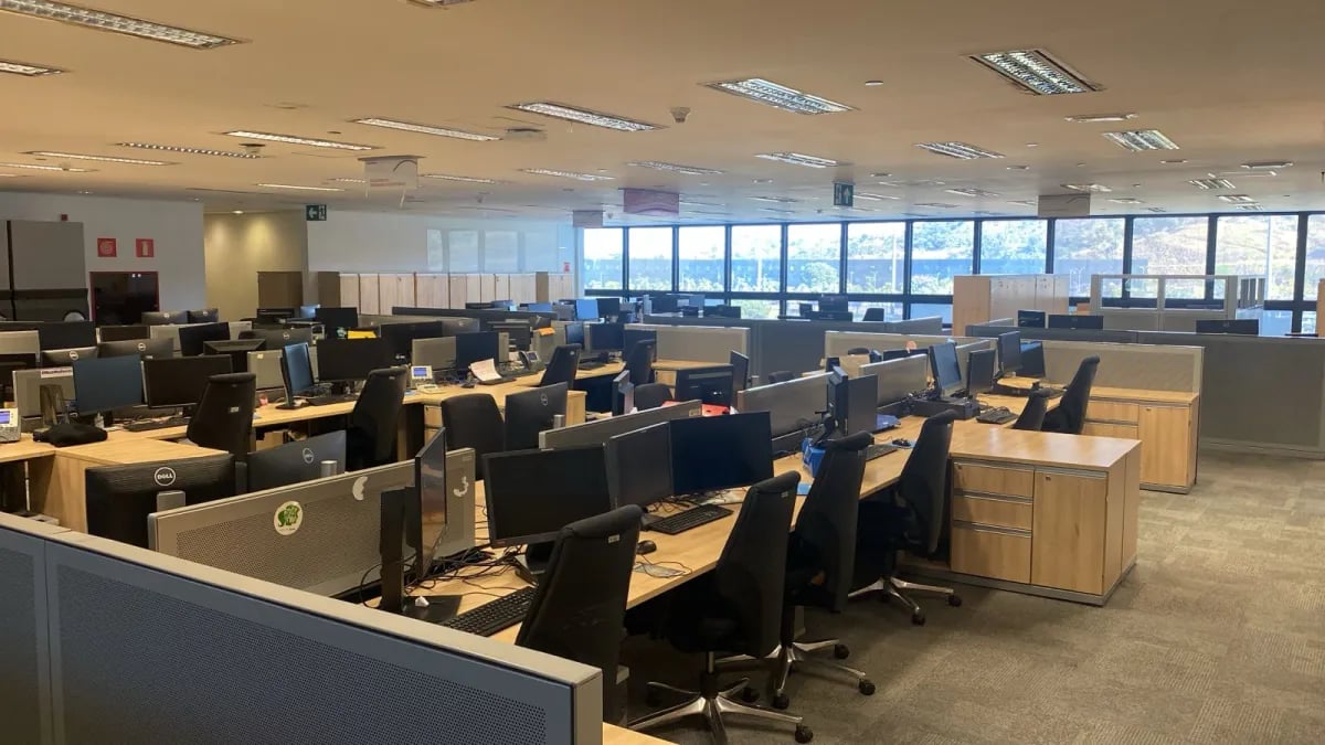 Ambiente de atendimento administrativo com balcões e estações de trabalho; imagem ilustrativa das atividades de Oficial Administrativo