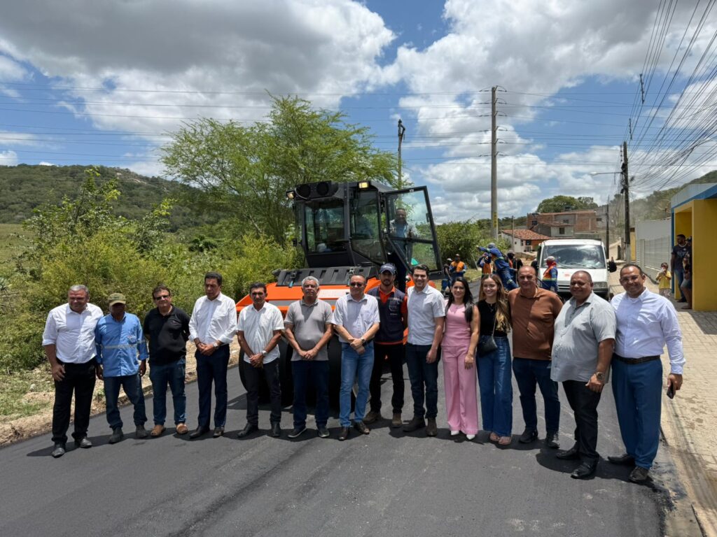 Máquina patrol e equipe em obra de estrada rural, ilustrando manutenção viária