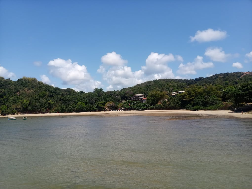 Orla no Recôncavo Baiano, com mar calmo e embarcações artesanais