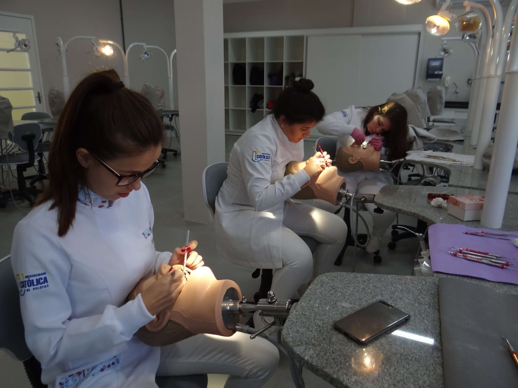 Ambiente acadêmico de Odontologia com cadeiras odontológicas e prática em laboratório
