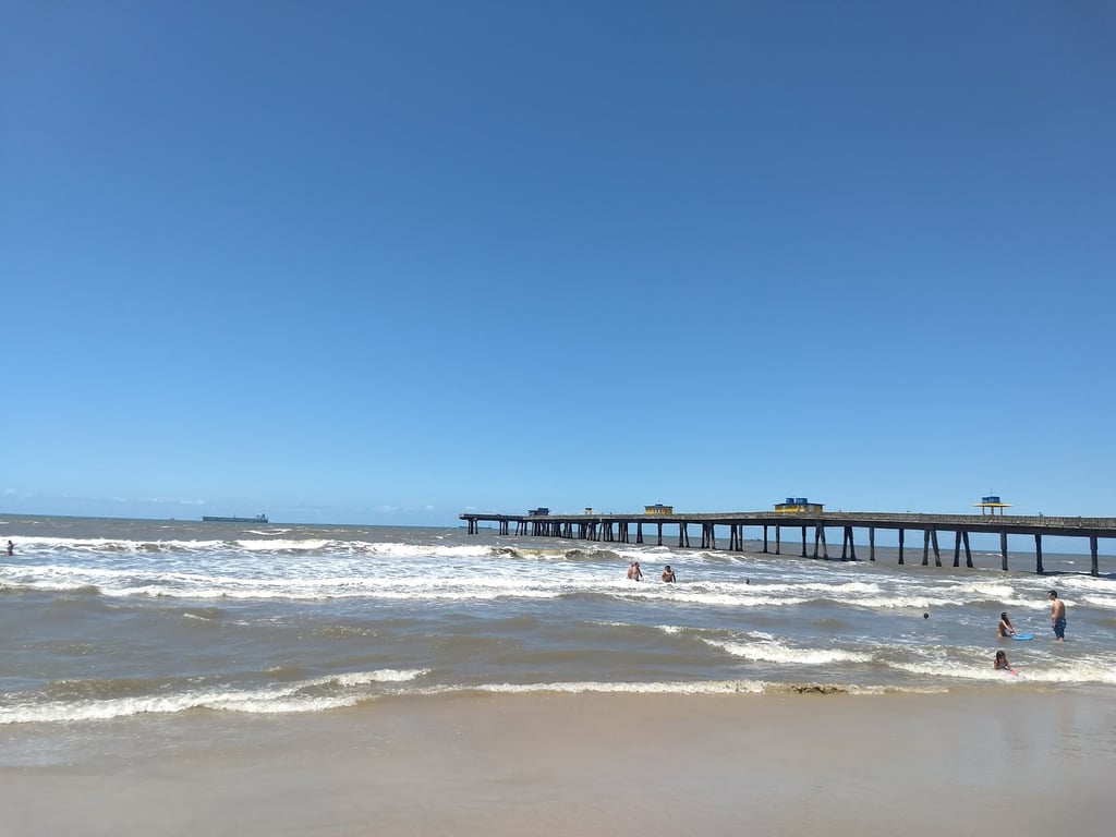 Vista aérea da orla de Tramandaí e Imbé, com os molhes ao pôr do sol