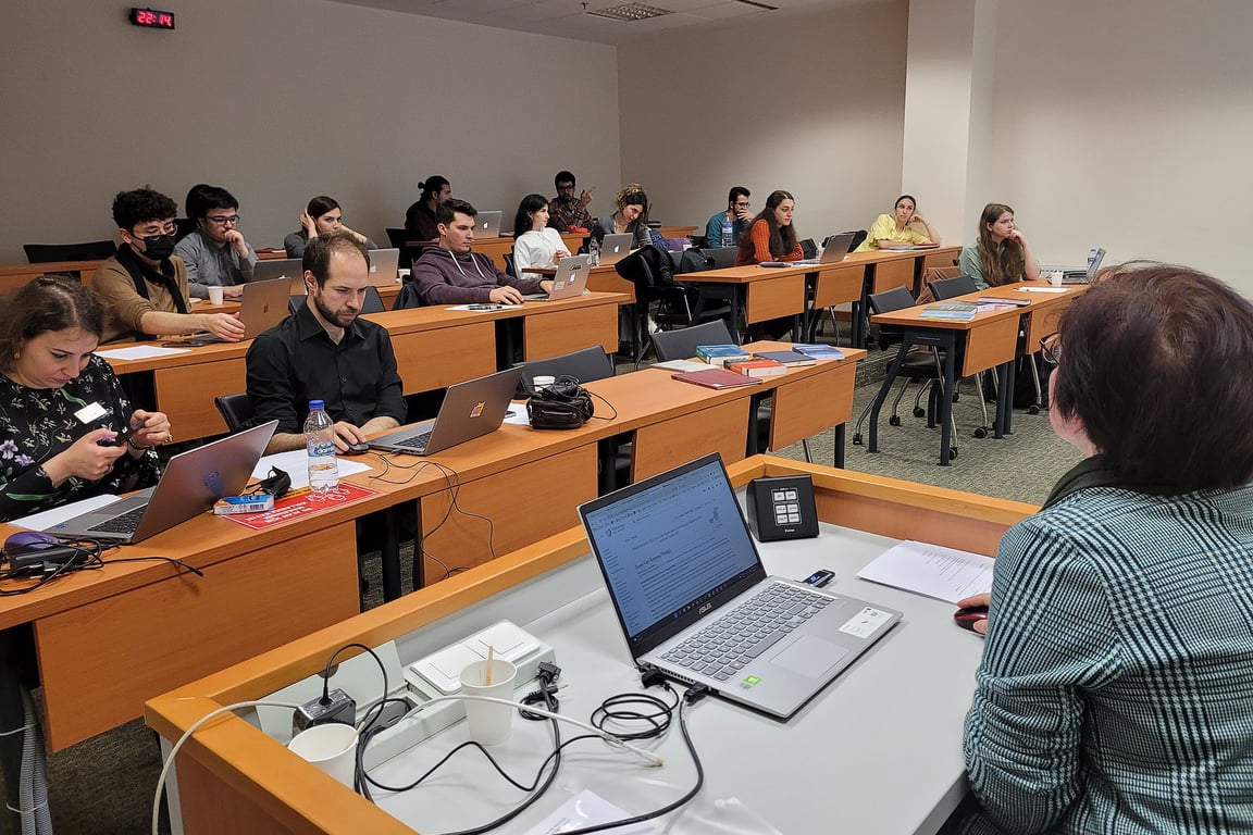 Ambiente acadêmico em sala de aula com foco em interação entre docentes e alunos