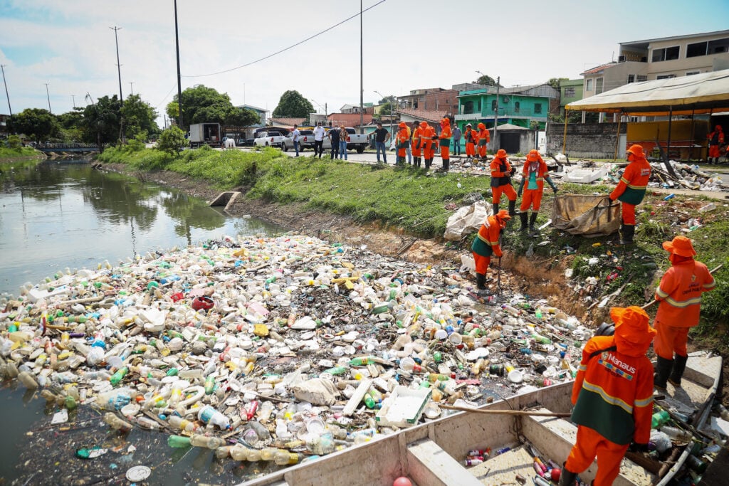 Trabalhadores de limpeza urbana em atividade, com uniformes e equipamentos