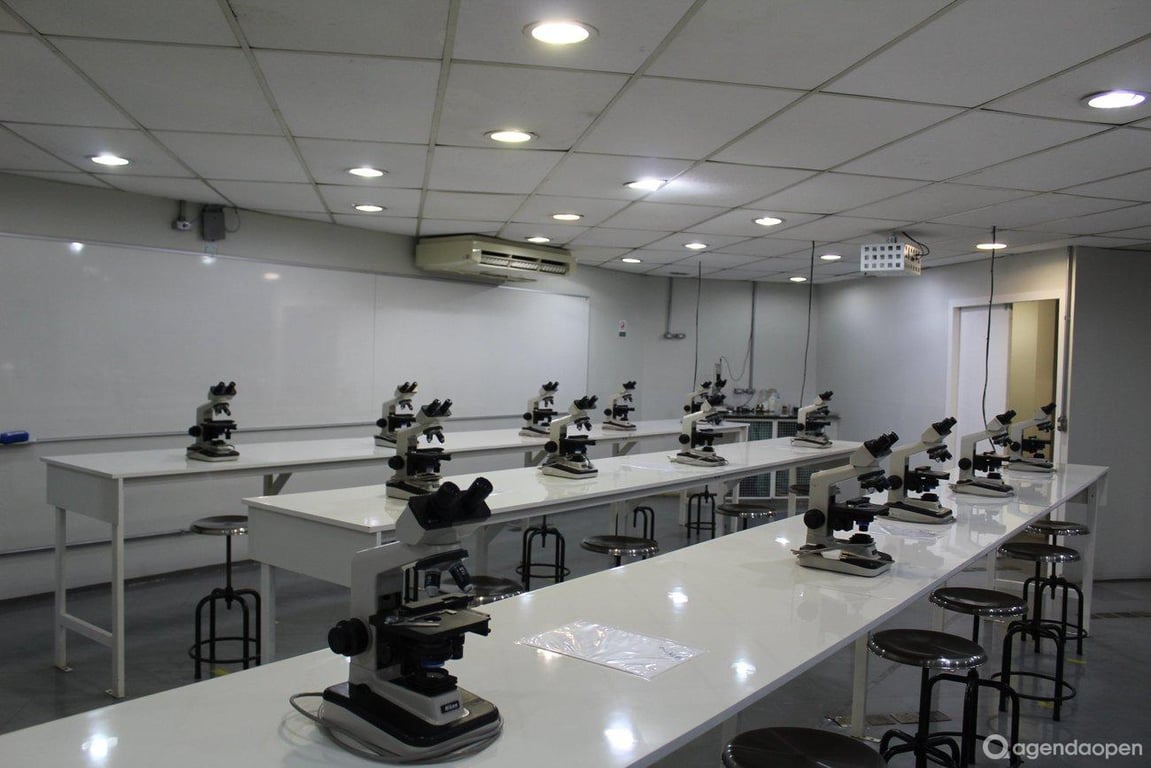 Laboratório escolar moderno com bancadas, microscópios e quadro branco