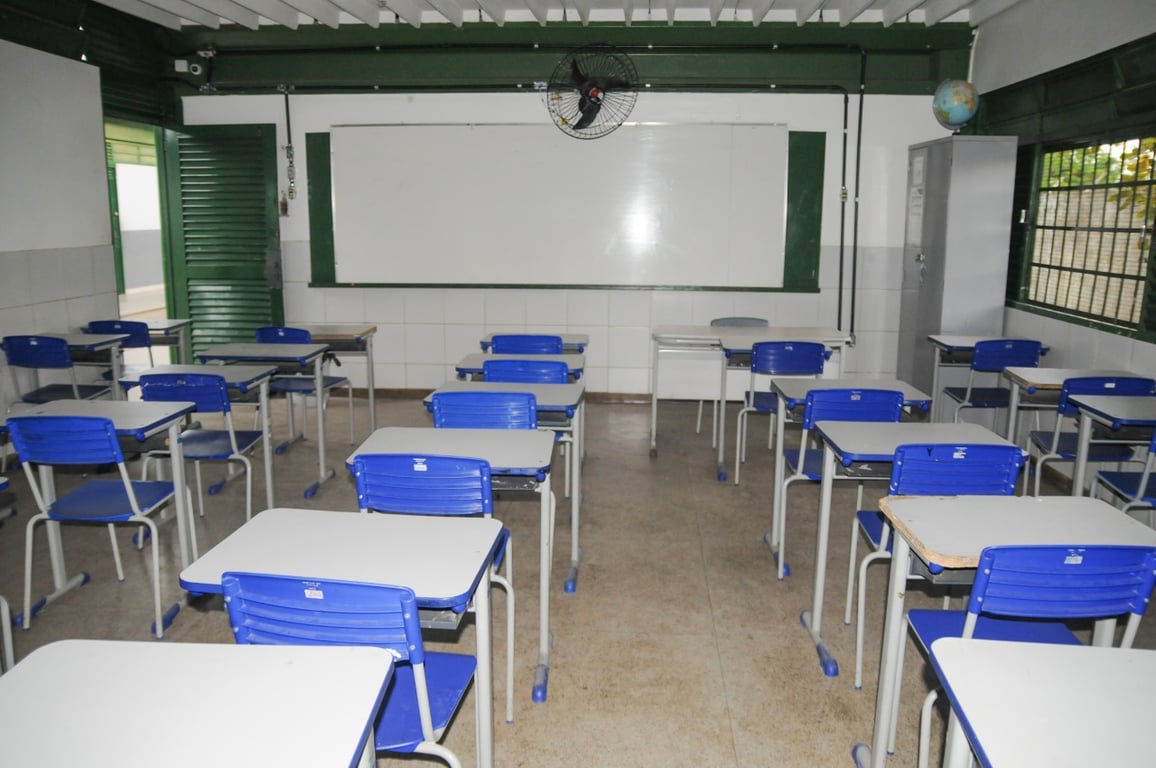 Sala de aula de escola pública com carteiras e quadro, sem alunos
