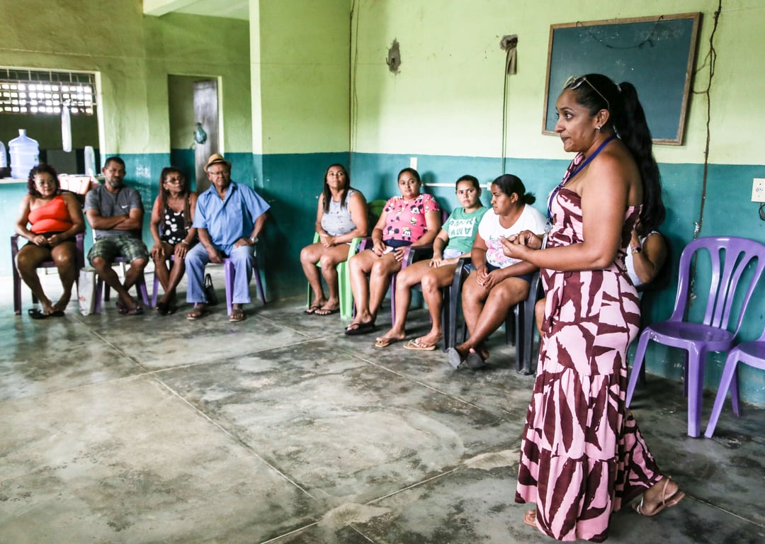 Atividade de assistência social em espaço comunitário, com público e servidora em apresentação