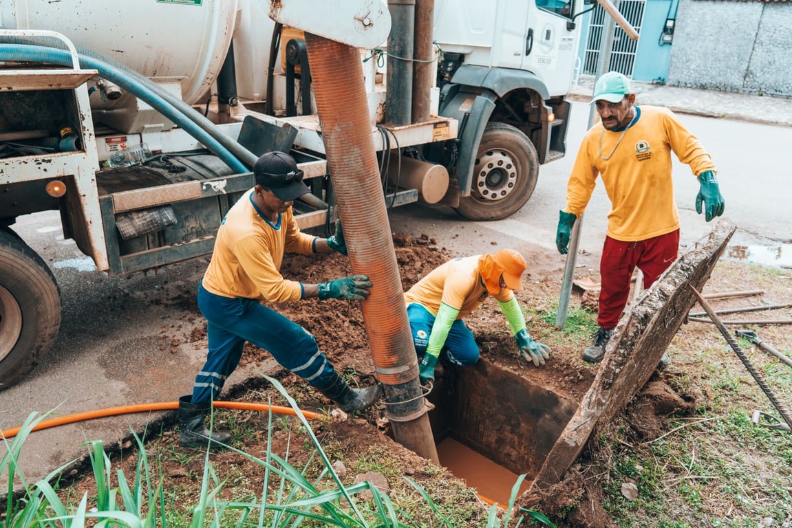 Profissionais de saneamento trabalhando próximos a reservatório de água e caminhão-pipa