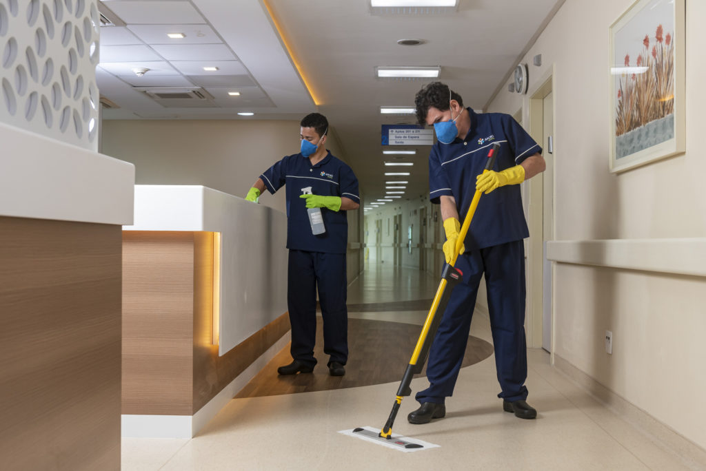 Equipe de limpeza hospitalar com EPI em ambiente clínico