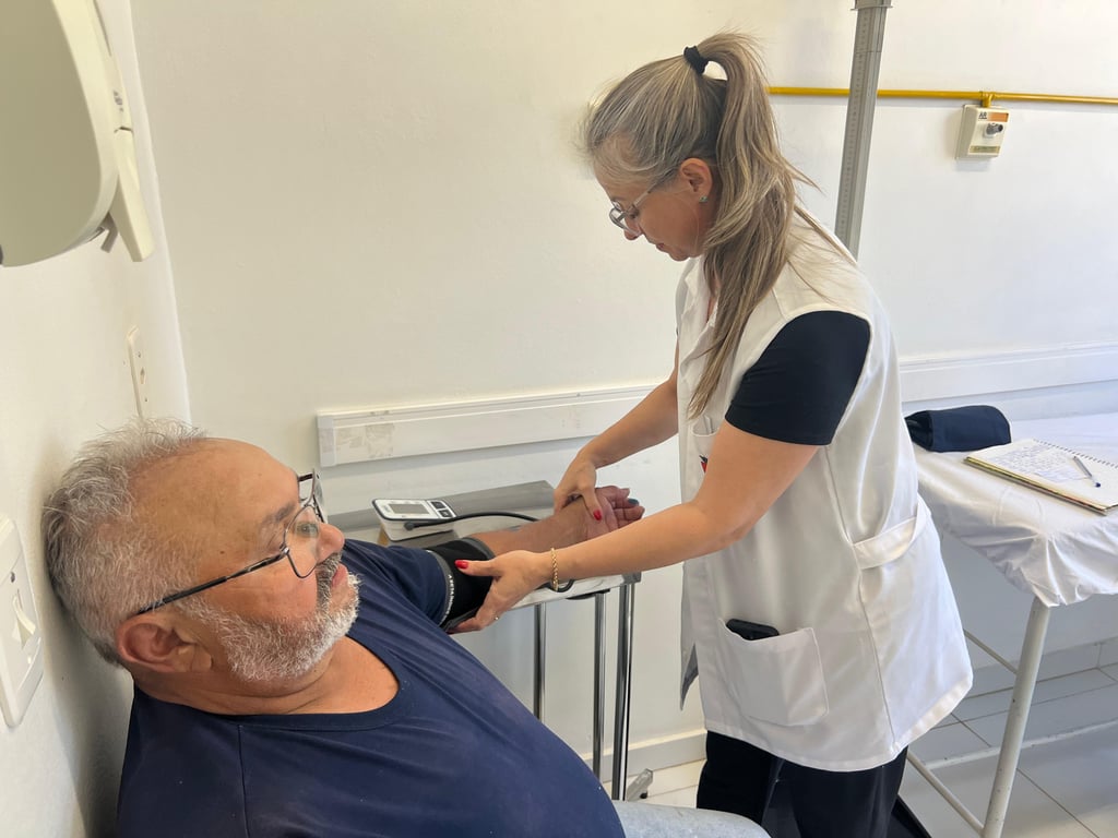 Profissional de saúde auxilia paciente em unidade pública, com foco no acolhimento e na mobilidade