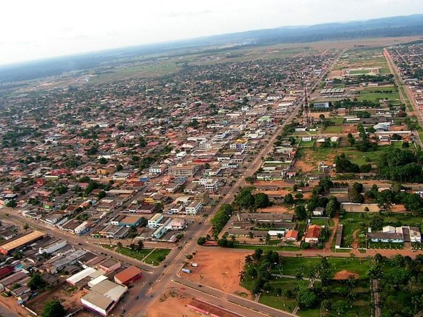 Vista aérea de Ariquemes RO ao entardecer, com área urbana e vias centrais em destaque