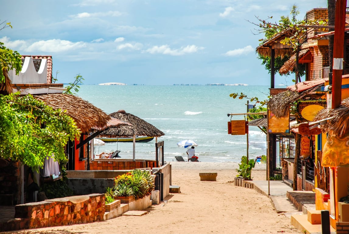 Rua charmosa na vila de Barra Grande com restaurantes rústicos e palmeiras ao entardecer