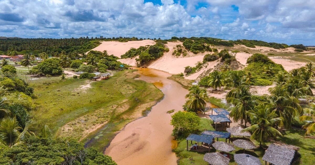 Vista aérea da Lagoa do Peixe, com lagoas, dunas e a faixa do Atlântico sob luz dourada