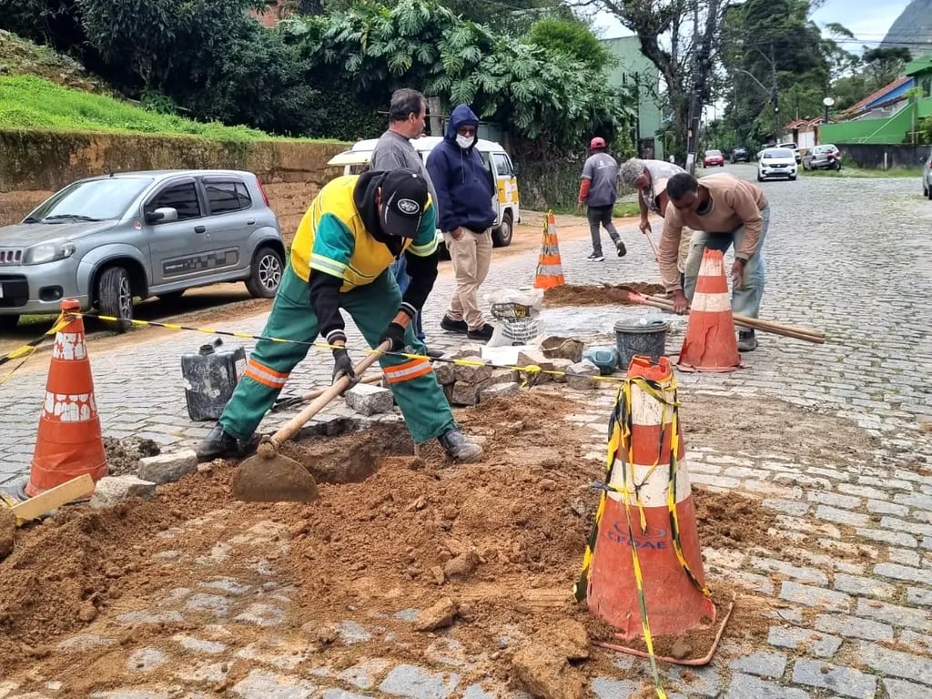 Equipe de manutenção urbana em atividade de jardinagem, com ferramentas de poda e roçagem em jardim público