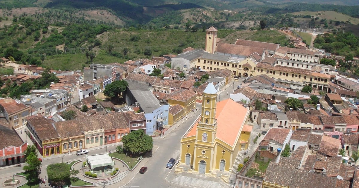 Praça no interior da Paraíba, com igreja e árvores ao entardecer