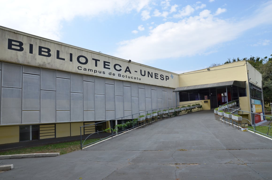 Fachada da UNESP com área acadêmica e vegetação