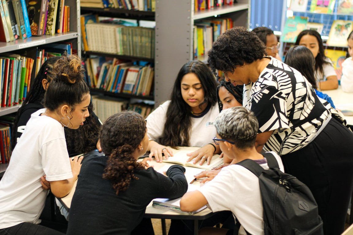 Professora mediando atividades com alunos em reforço escolar