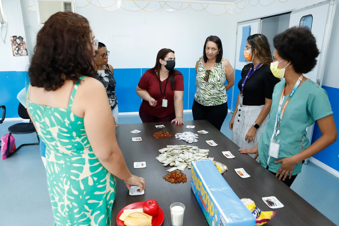 Equipe multiprofissional em unidade básica de saúde, durante reunião de atendimento e planejamento