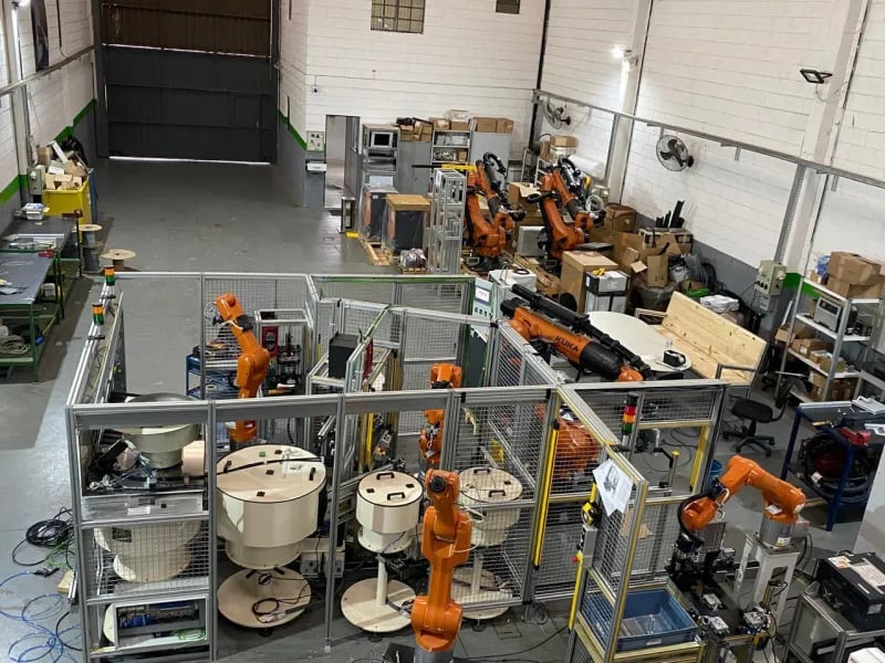 Laboratório de automação industrial com robôs e painéis elétricos organizados