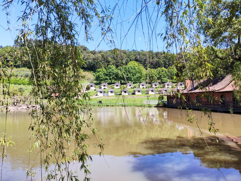 Paisagem da Região da Uva e do Vinho no Nordeste do Rio Grande do Sul, com vinhedos e lago ao pôr do sol