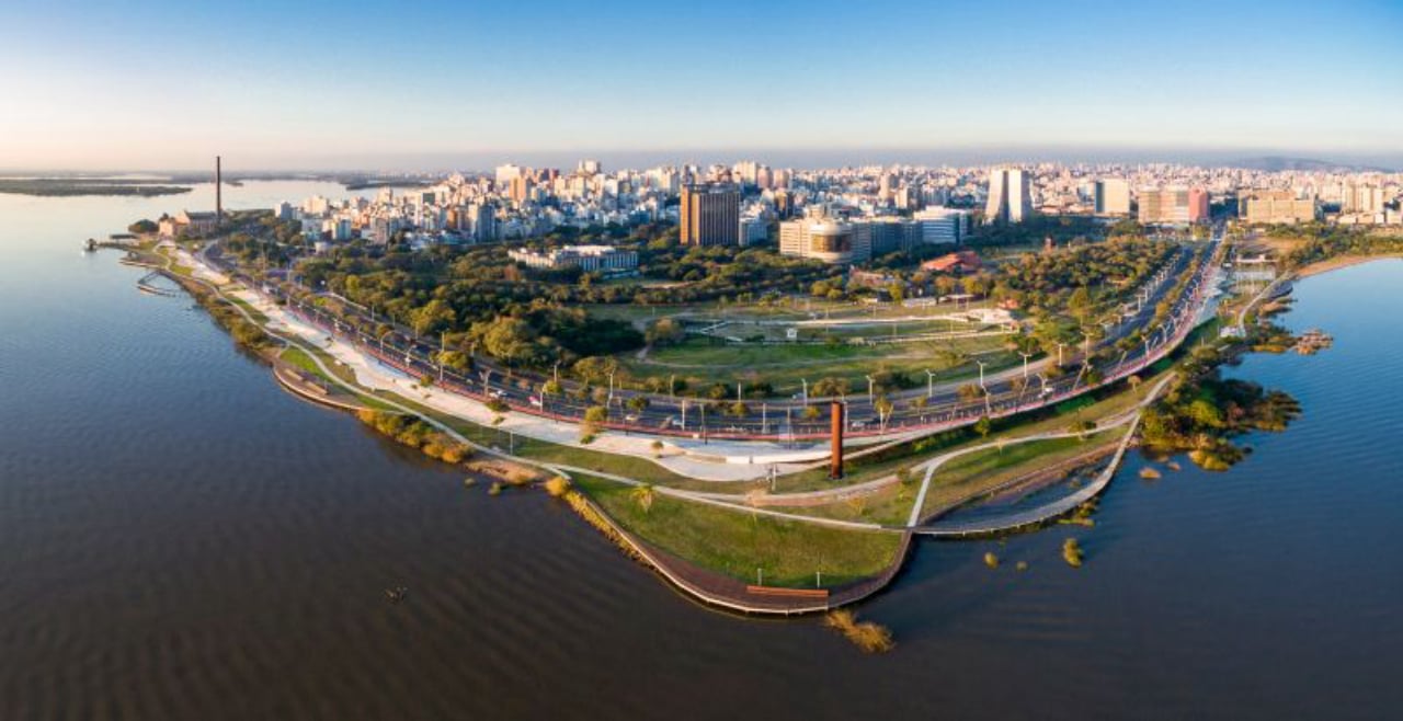 Porto Alegre e o Lago Guaíba ao entardecer, com skyline urbano
