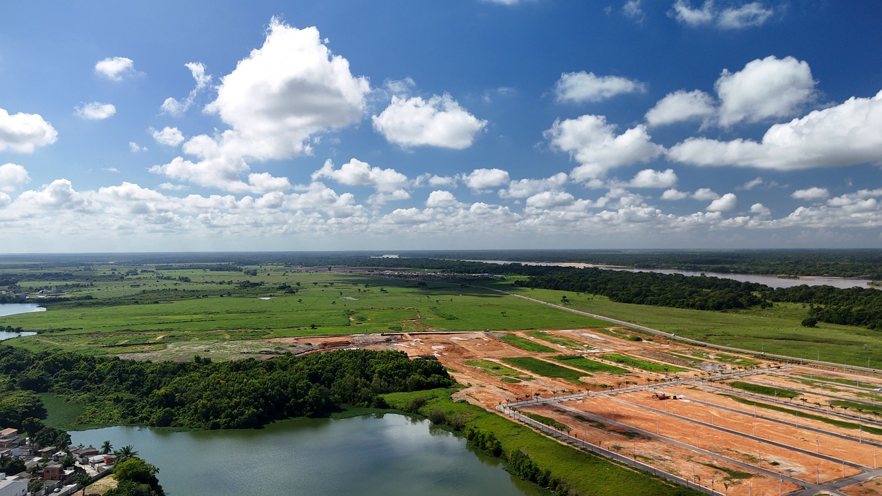 Vista aérea de Linhares, com lagoas e área urbana ao fundo, sob céu claro