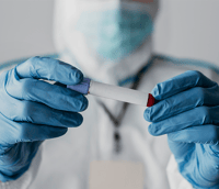 Profissional atuando em laboratório de hemoterapia e hematologia com tubos de ensaio.