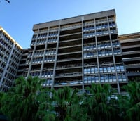 Fachada do campus Maracanã da UERJ no Rio de Janeiro, com o prédio principal em destaque e vegetação ao redor.