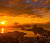 Vista aérea de Volta Redonda RJ ao pôr do sol, com o rio Paraíba do Sul e a cidade ao fundo