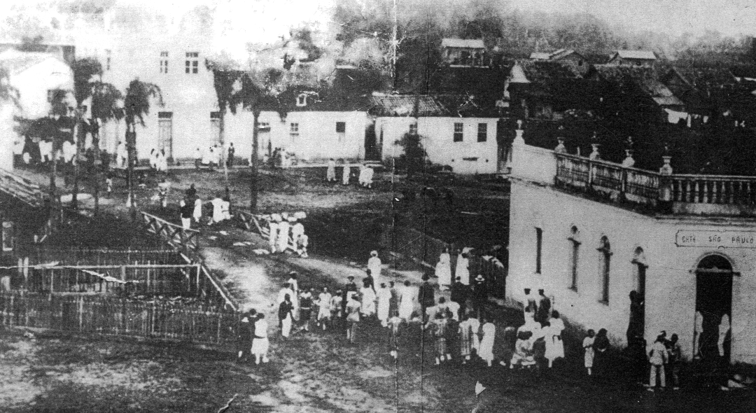 Praça em cidade do interior paulista, com comércio local e árvores