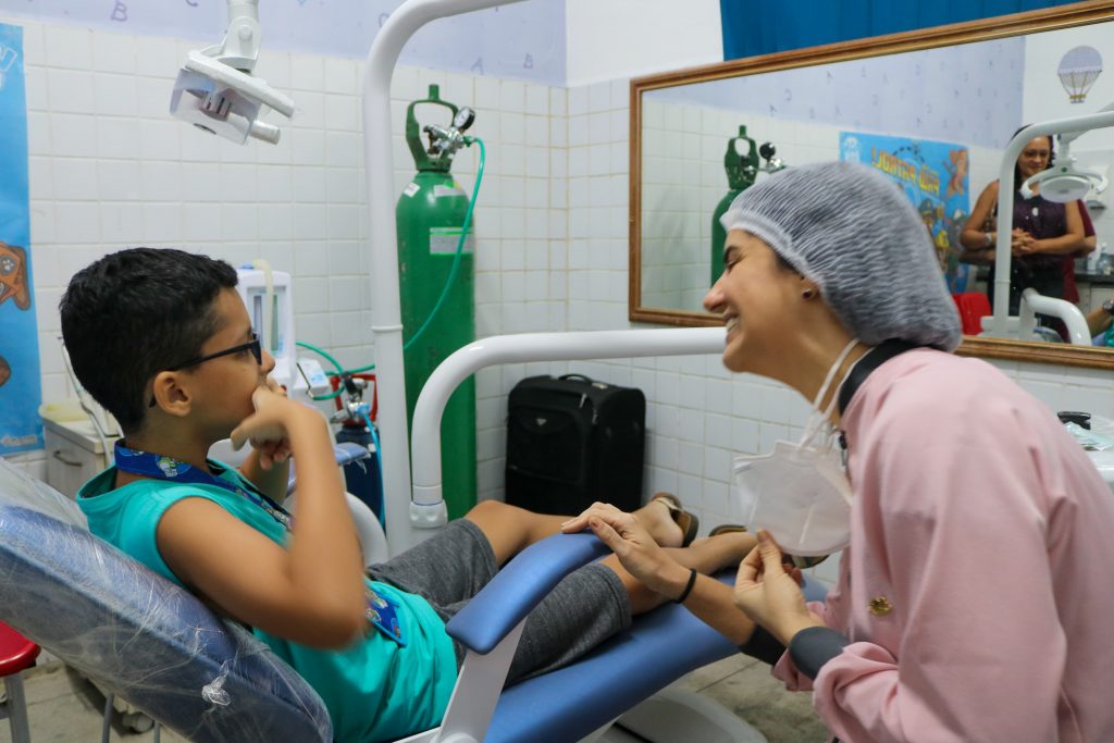 Atendimento em unidade móvel odontológica, com criança em cadeira de dentista